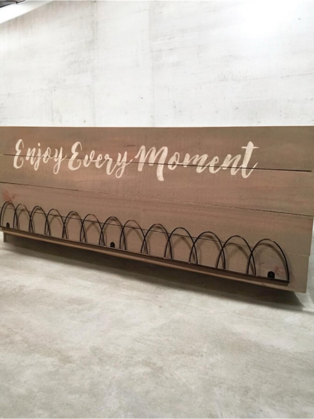 Rustic farmhouse-style wooden wall sign features a "Enjoy Every Moment" quote